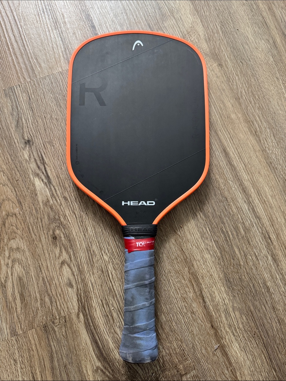 HEAD Black Pickleball Paddle with Orange Trim and Gray Grip